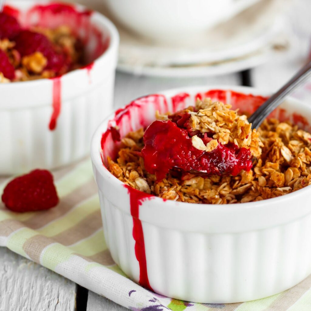 Crumble mit Haferflocken wird in einem kleinen Auflaufförmchen serviert.
