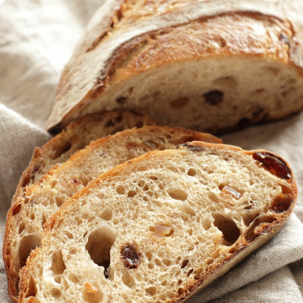 Kartoffelbrot mit Speck wird angeschnitten gezeigt