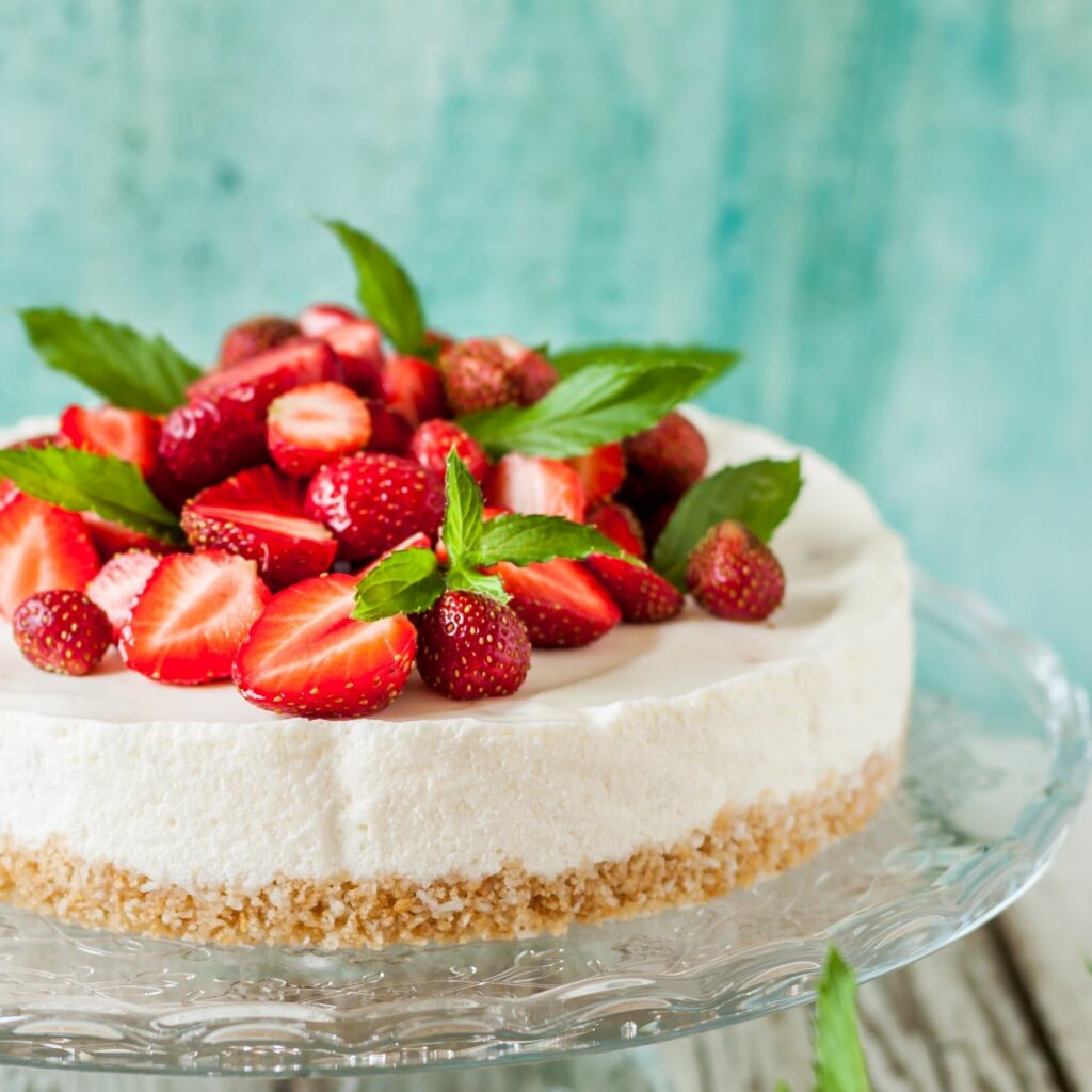 No Bake Cheesecake wird auf einer gläsernen Tortenplatte serviert.