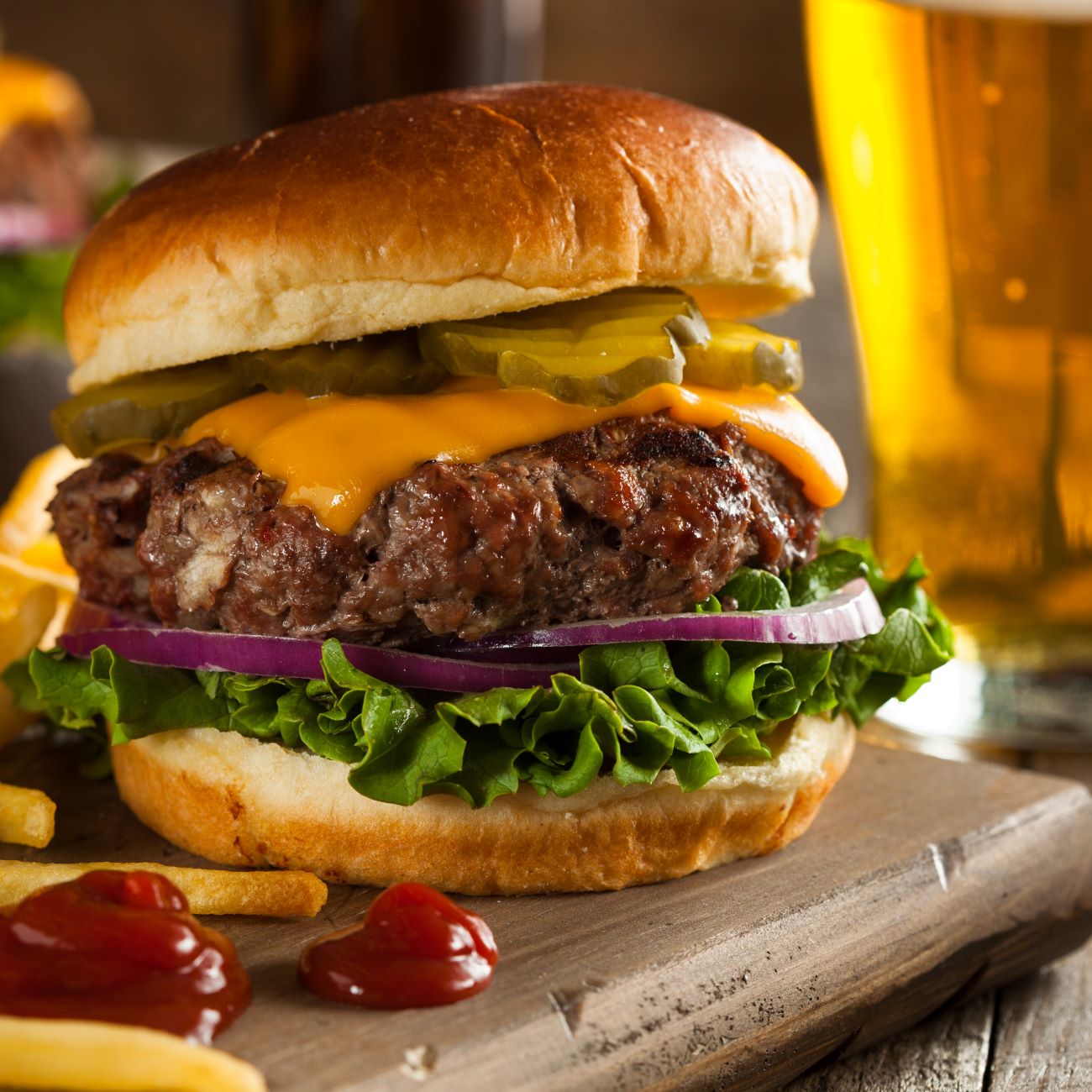 Cheeseburger je prikazan od blizu in s krompirčkom ob strani.