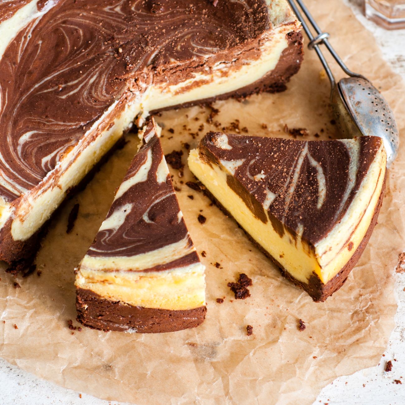 Marmorni cheesecake predstavimo prerezan na papirju za peko.