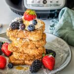 Veganer French toast wird gestapelt mit Beeren gezeigt.