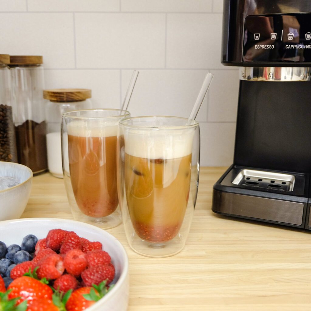 Eiskaffee mit Himbeer-Sirup wird mit Früchten gezeigt.