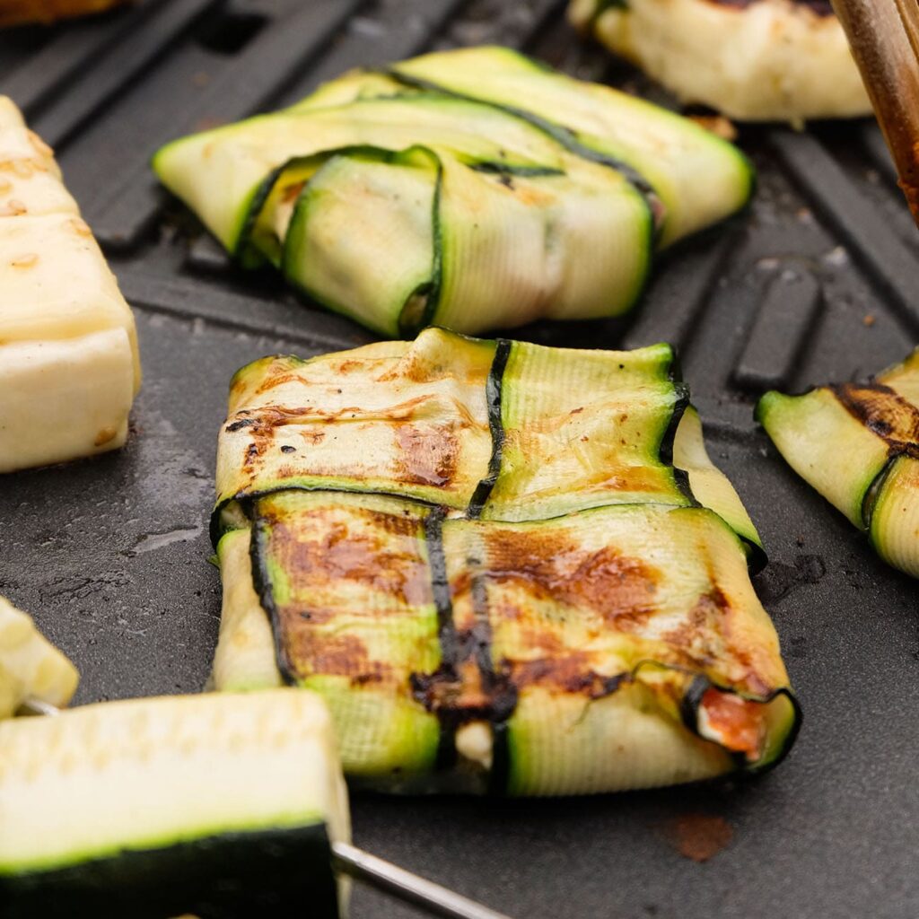 Zucchini Päckchen werden auf dem Grill gezeigt.